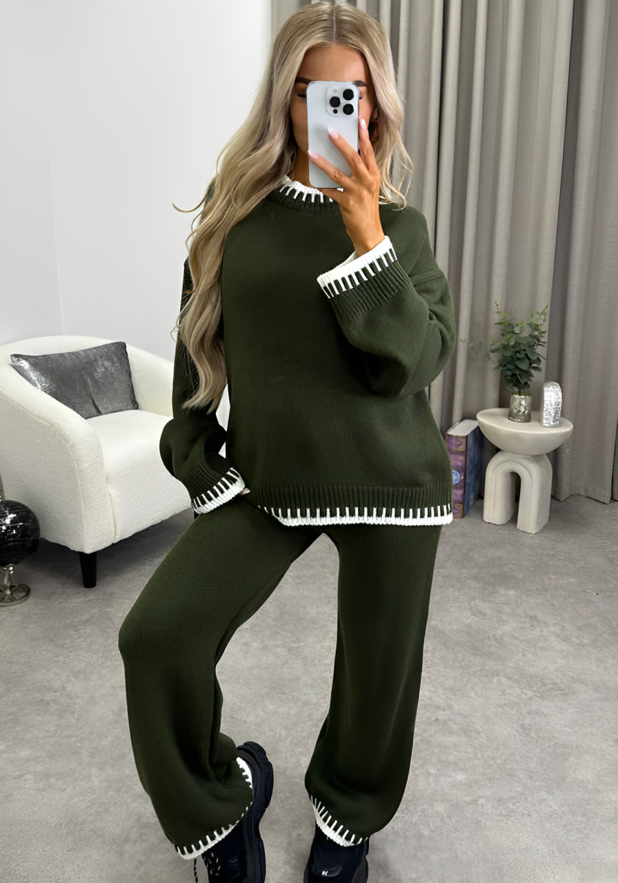 A woman taking a selfie and wearing green knitted sweater and pants set.